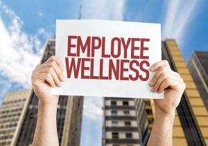 Person holding “Employee Wellness” sign