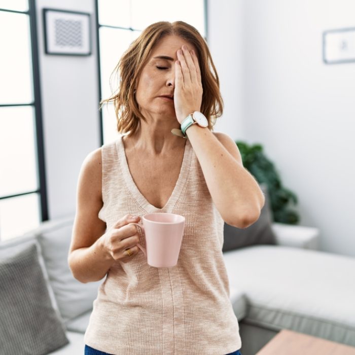 Middle,Age,Woman,Drinking,A,Cup,Coffee,At,Home,Yawning